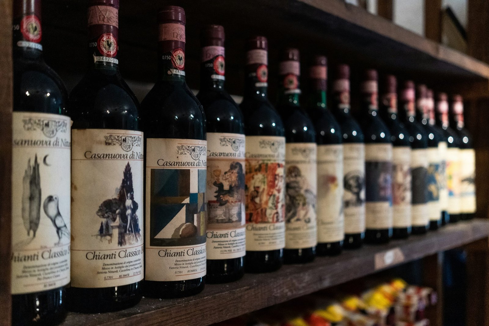 Shelf of Italian Chianti Classico wine bottles in a dark setting